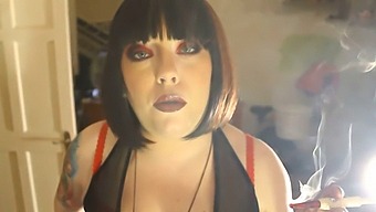 Fat Domme Tina Smokes A Cigarette In A Holder While Wearing Leather